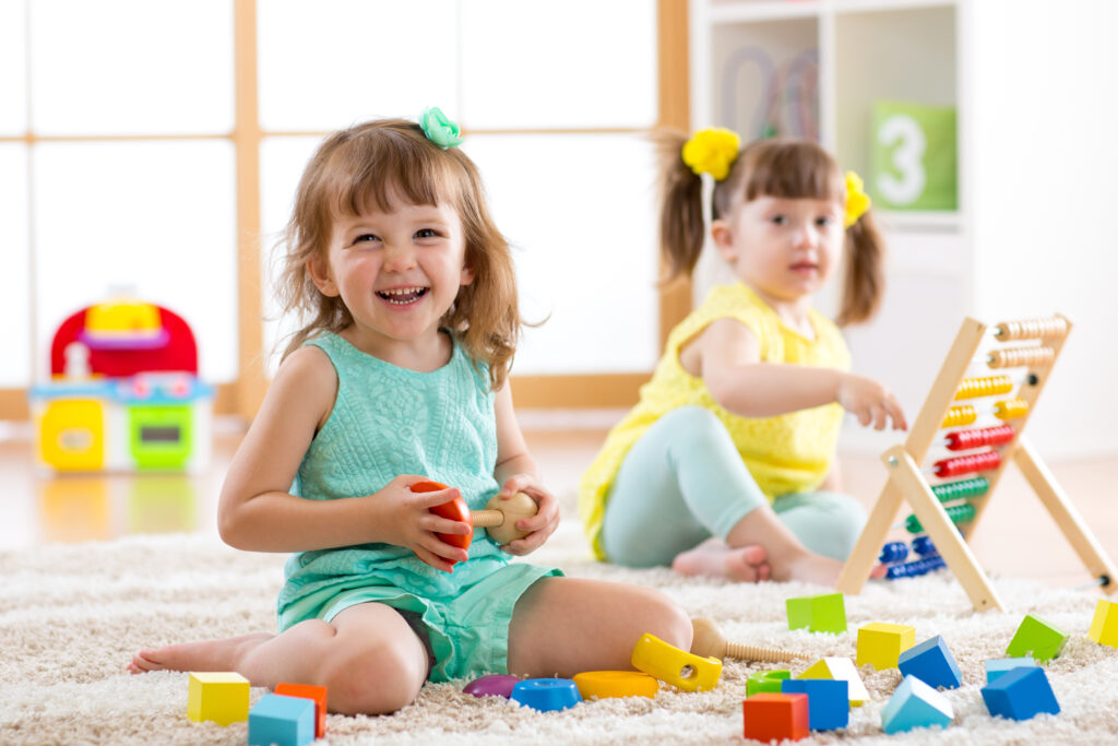 Two toddlers playing with building blocks together